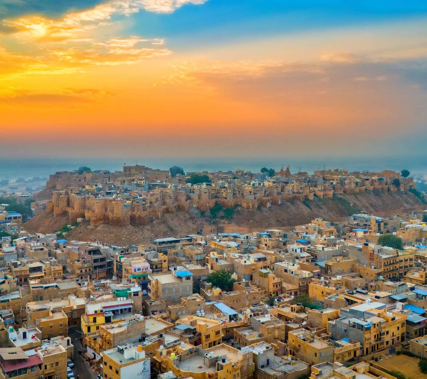 Jaisalmer Fort rising above the golden sandstone houses of the old city at sunrise