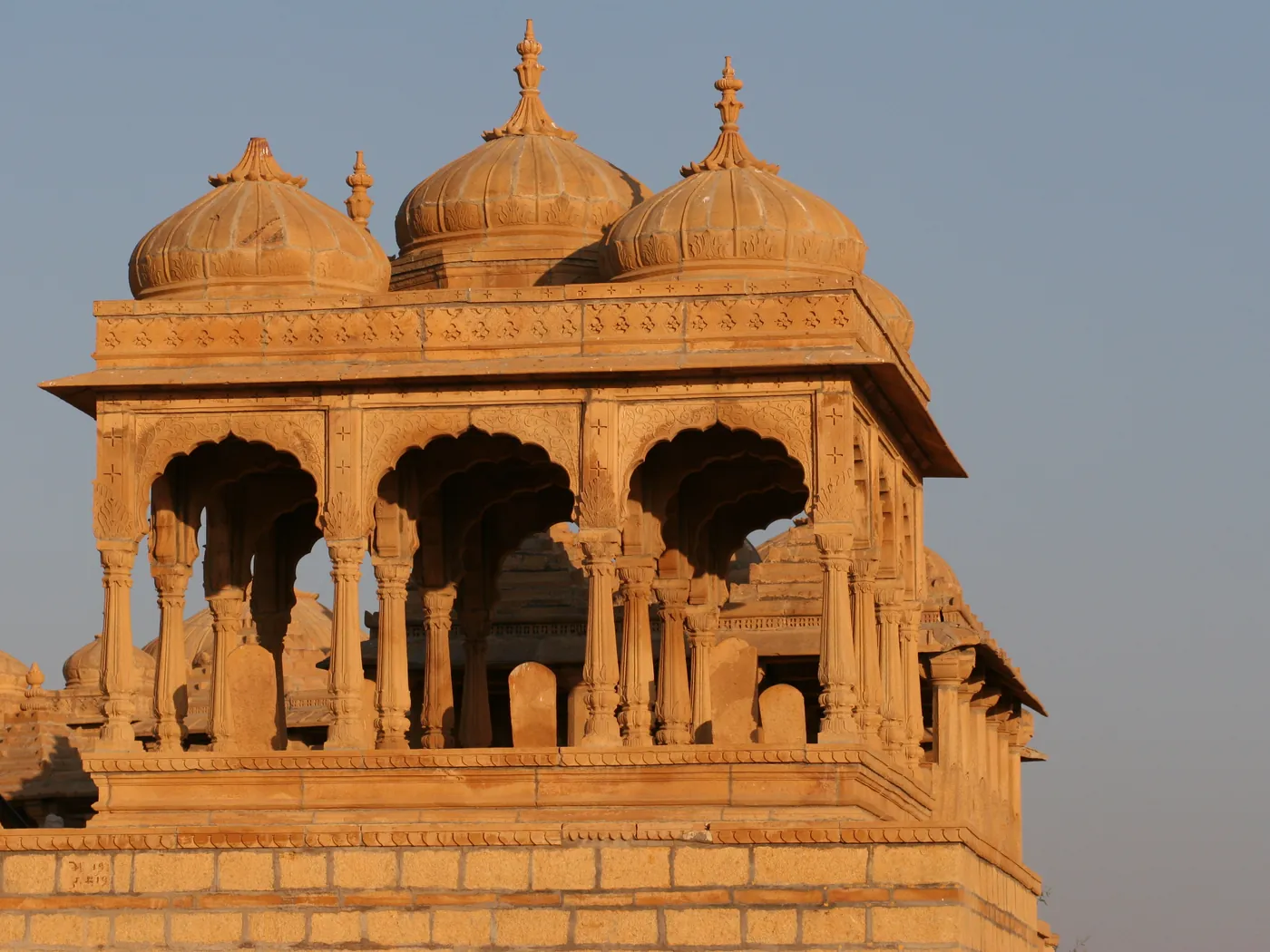Domed sandstone cenotaphs at Vyas Chhatri, Jaisalmer, lit by low sun